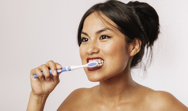 Saúde em dia: mulher escovando os dentes