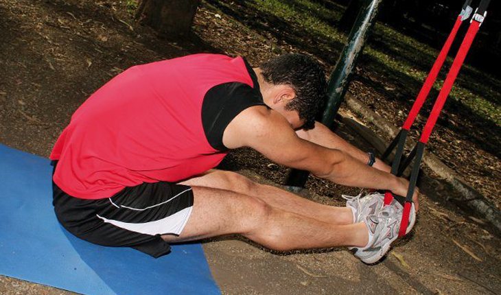 homem se alongando com uma fita alongamentos com fita