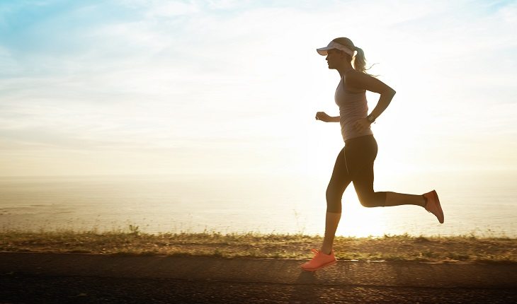 Motivos para a corrida entrar de vez na sua vida: mulher correndo paisagem sol