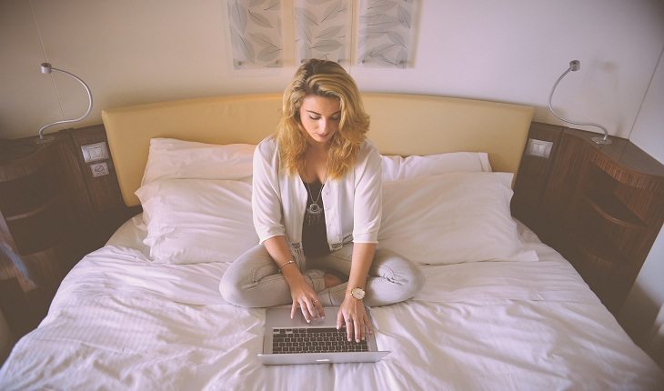 Mulher em cama com um notebook memória