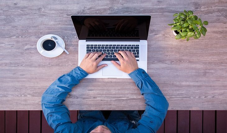 homem sentado com um notebook sobre a mesa memória