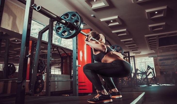 foto de uma mulher realizando o exercício de agachamento