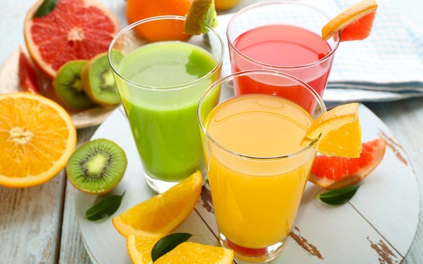 Receitas de sucos funcionais: na foto, três copos de sucos e frutas envolta