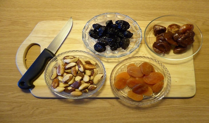 imagem de algumas frutas secas em recipientes em cima de uma tábua de carnes cuidados no inverno