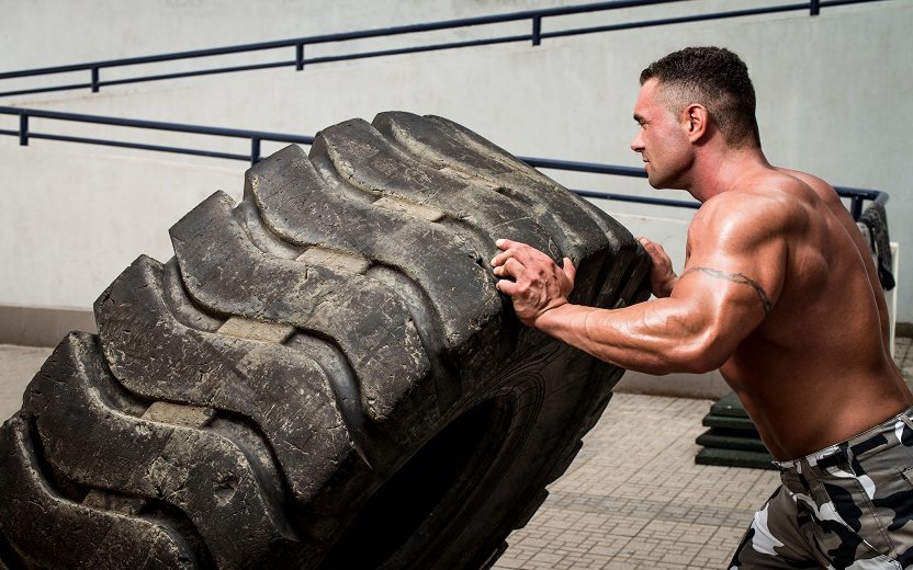 Homem sem camisa praticando um dos exercícios do CrossFit