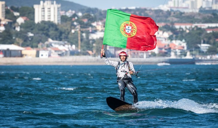 Português Francisco Lufinha com a bandeira de seu país, praticando kitesurf