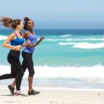 Imagem duas mulheres correndo na pria dia ensolarado. Corrida