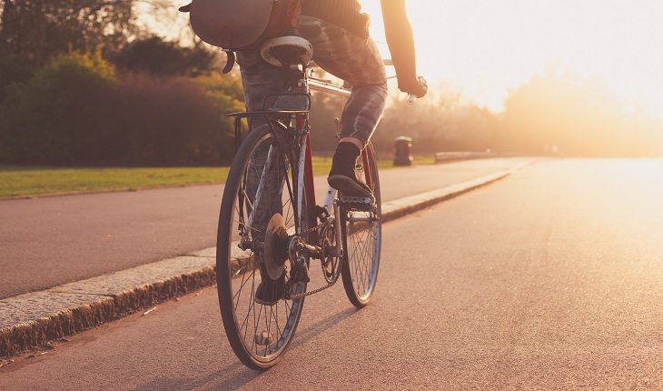 pessoa pedalando com um pôr do sol ao fundo