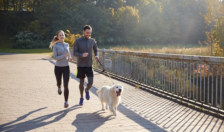 Correr com o cachorro: casal correndo