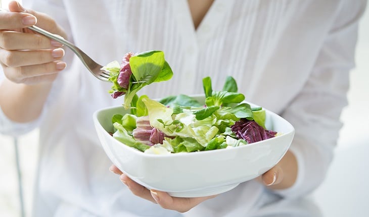 mulher comendo salada em uma tigela