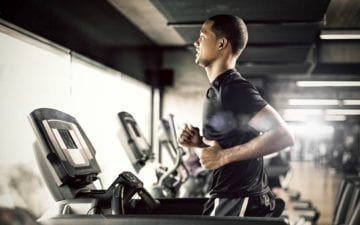 Homem realiza exercício físico na academia, correndo na esteira. Dicas para ficar em forma