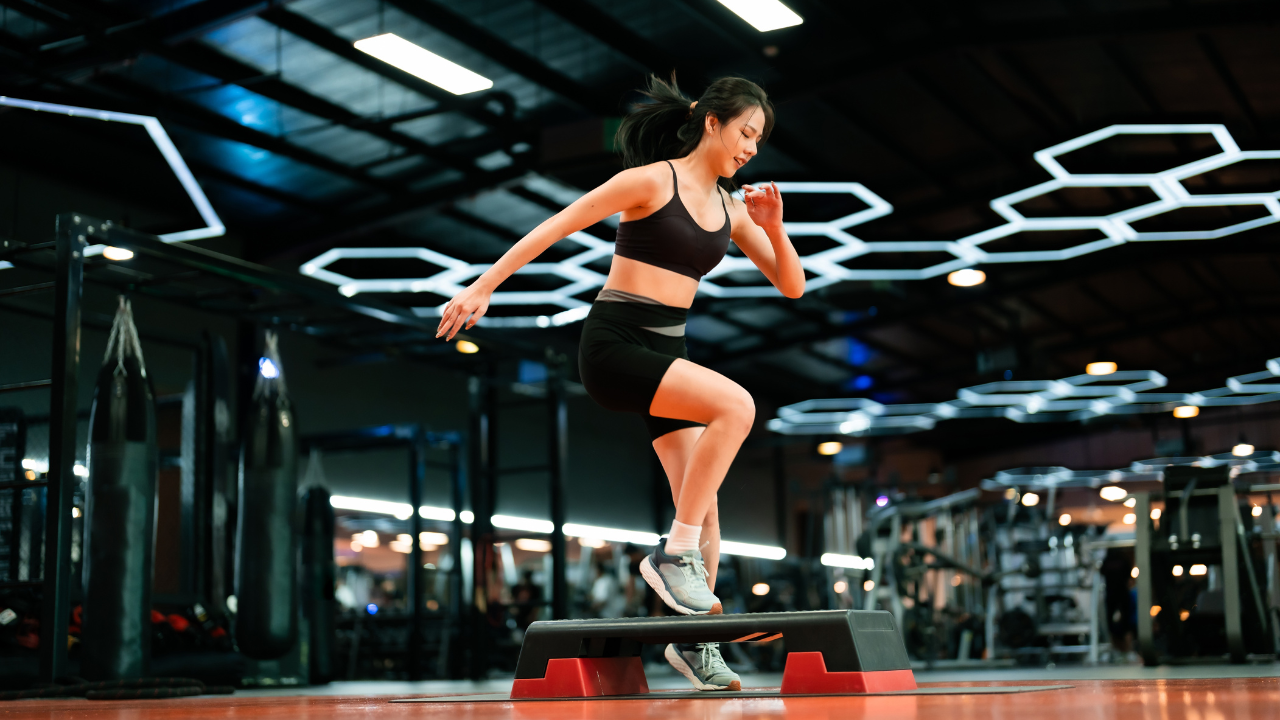 Imagem de uma mulher praticando HIIT em uma academia bem iluminada