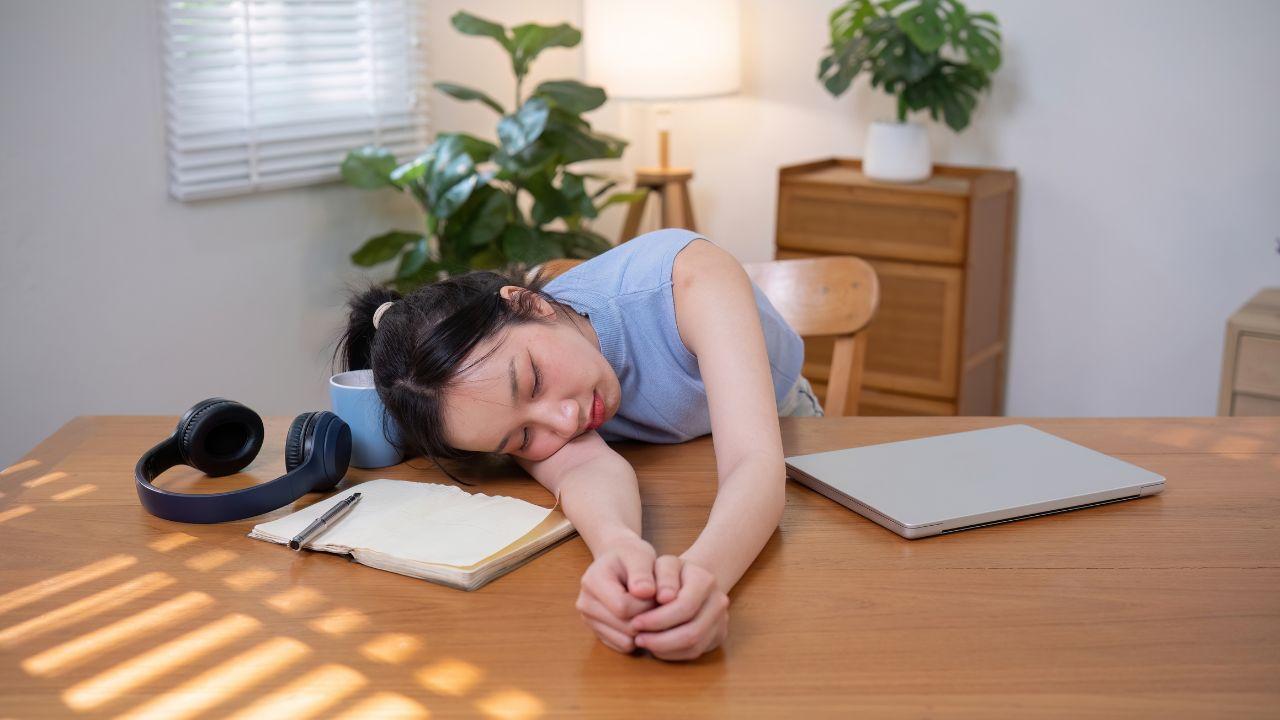 Imagem de uma mulher deitada na mesa de trabalho