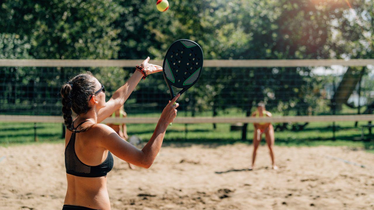 Mulheres de biquini jogando beach tennis.