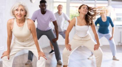 Imagem de uma sala de dança com pessoas de diferentes idades