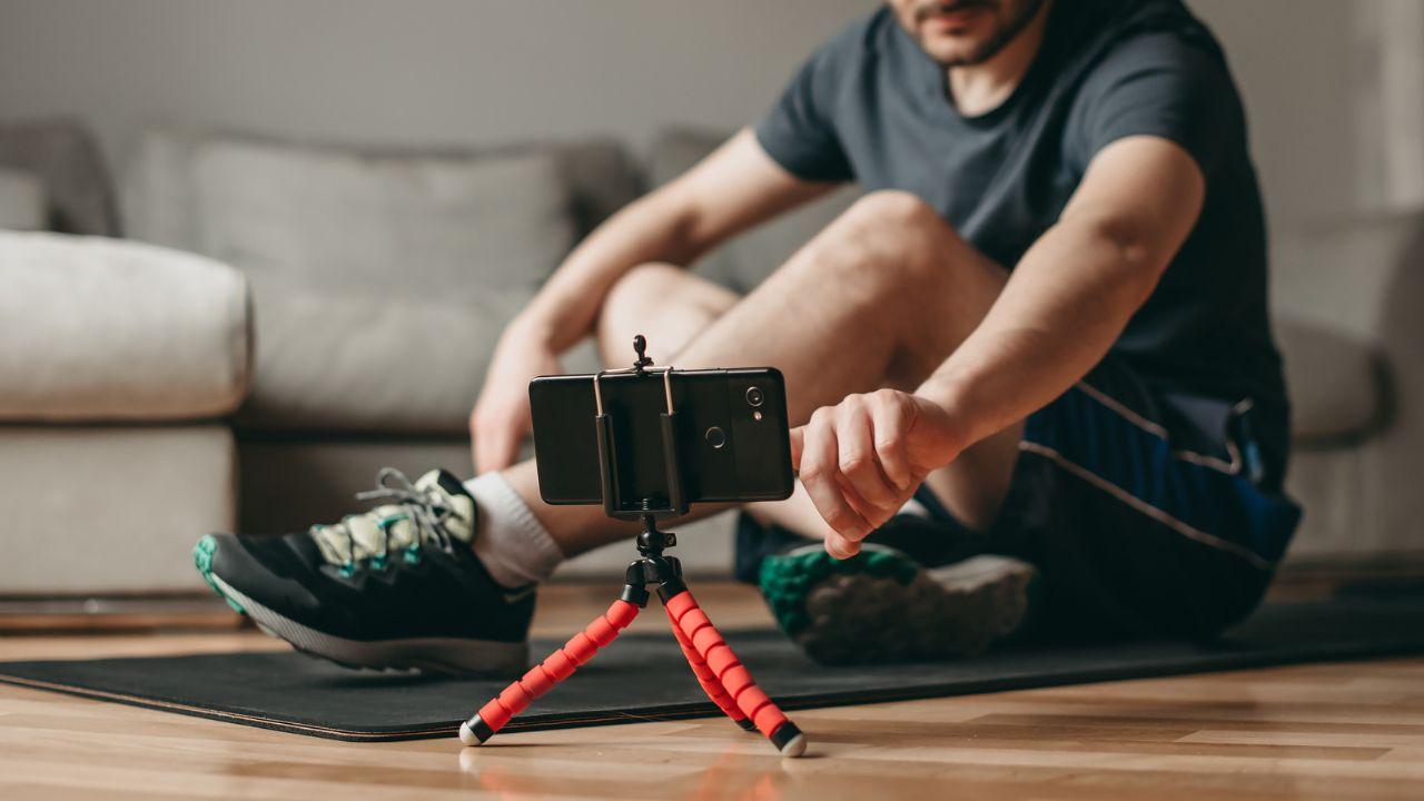 Imagem de um homem se preparando para treinar olhando no celular