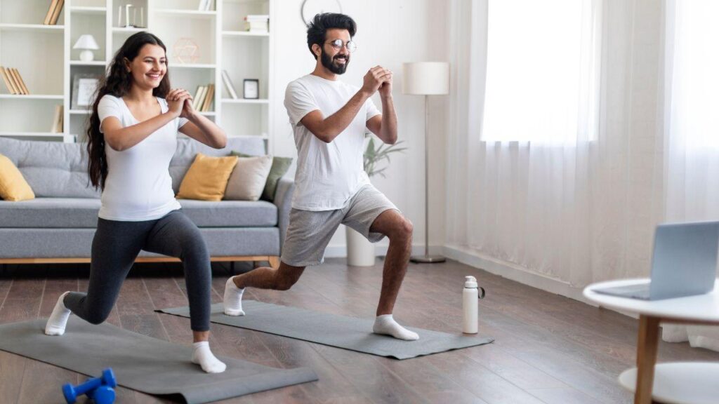 Imagem de um casal treinando na sala de casa