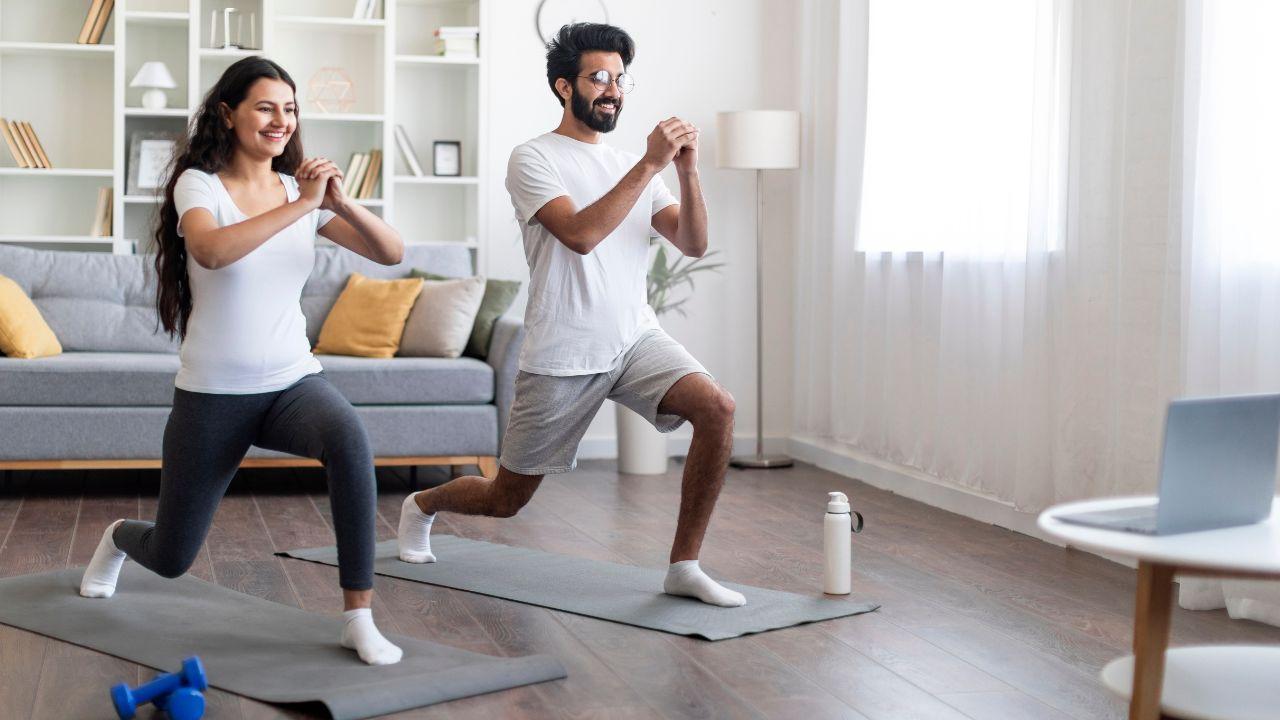 Imagem de um casal treinando na sala de casa