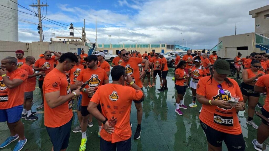 Pessoas usando camiseta laranja de corrida em pé ao ar livre.