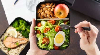 Foto mostra pessoa comendo marmita com ovo e verduras.