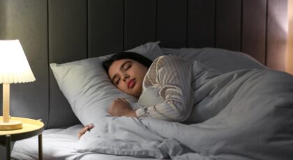 Mulher deitada na cama dormindo no escuro.