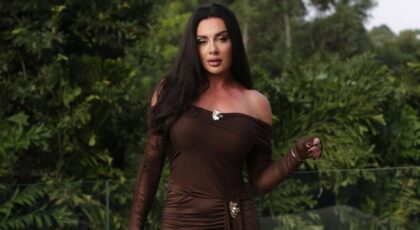 Juju Salimeni. Mulher branca, cabelo preto longo, usando vestido marrom.