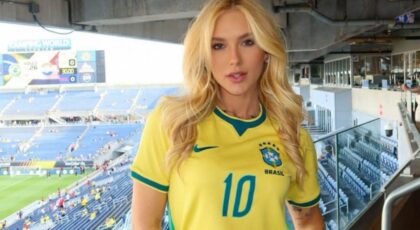 Virginia Fonseca sorrindo, usando camiseta da seleção brasileira, no estádio de futebol.