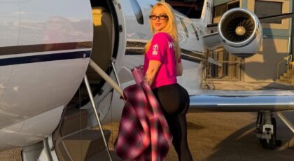 Foto mostra Virginia entrando no avião sorrindo e mostrando a parte de trás do corpo.