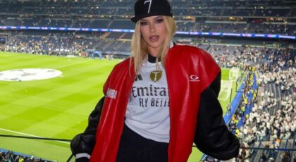 Virginia com roupa de time no estádio de futebol.