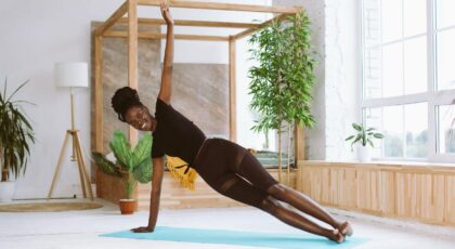 Imagem de uma mulher na posição de prancha lateral do Yoga