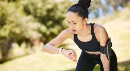 Mulher com roupa de exercício físico vendo o smartwatch.