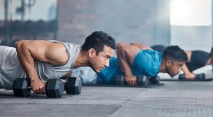 Homens fazendo exercícios com halteres na academia