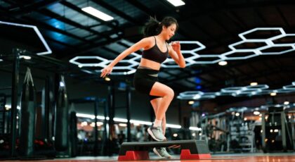 Imagem de uma mulher treinando na academia pulando em um jump