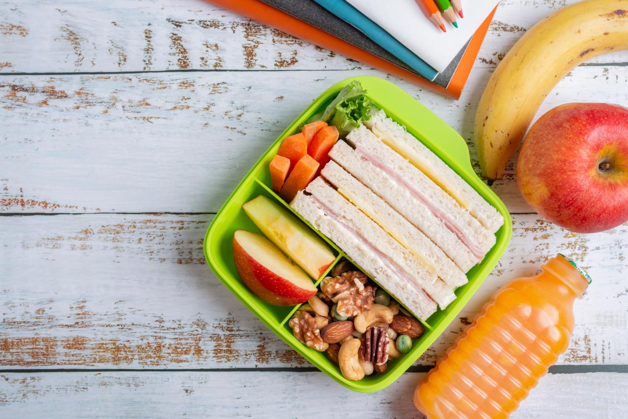 Foto mostra lanches de pães e frutas dentro de um potinho.