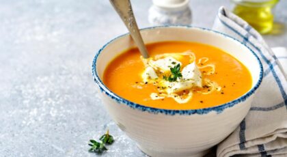 Foto mostra um prato de sopa em cima de uma mesa.