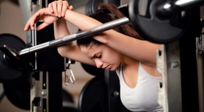 Mulher cansada após fazer musculação.
