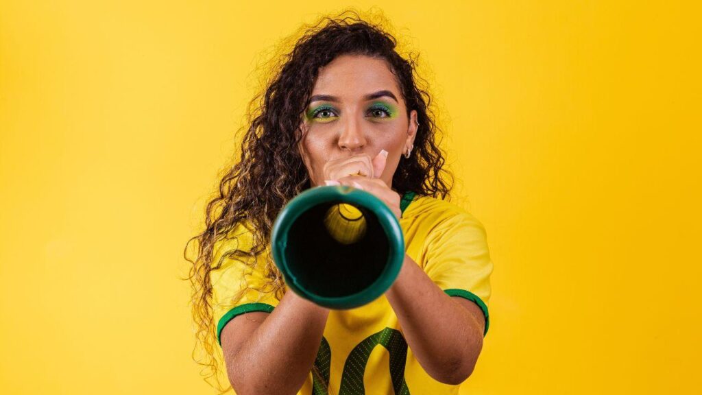 Imagem de uma mulher assoprando uma vuvuzela