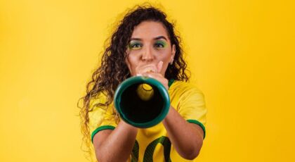 Imagem de uma mulher assoprando uma vuvuzela