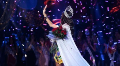 Foto mostra uma miss no palco fazendo o tchauzinho de miss.