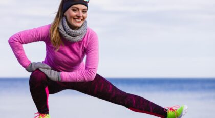 Mulher com roupa de frio fazendo exercício ao ar livre.