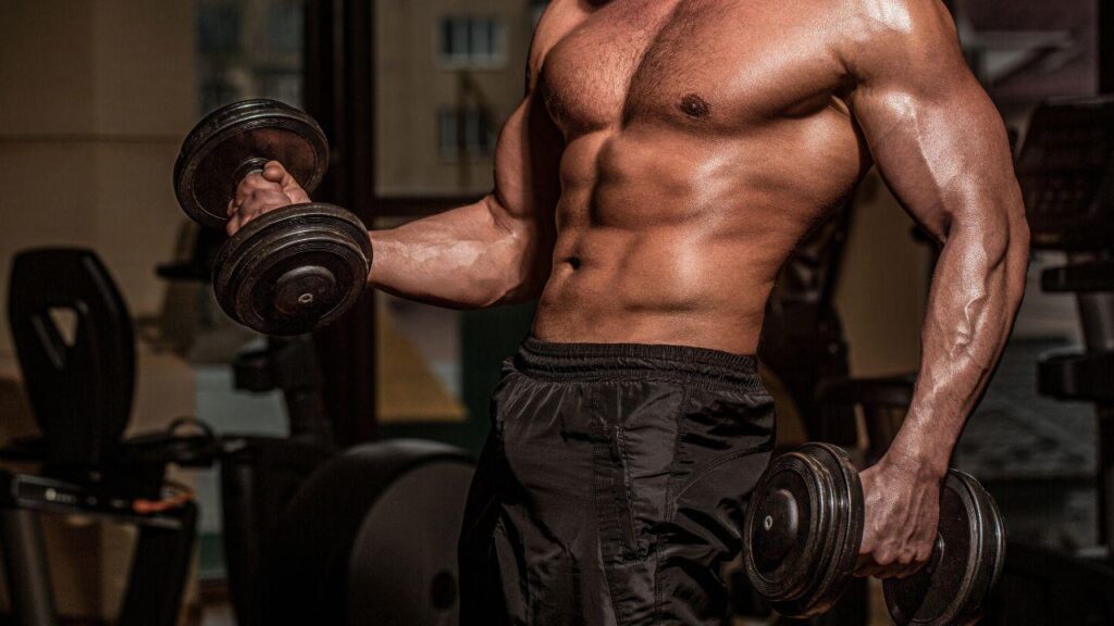 Imagem de um homem musculoso segurando dois halteres sem camisa