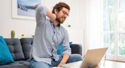 Imagem de um homem com a mão no pescoço sentindo dor