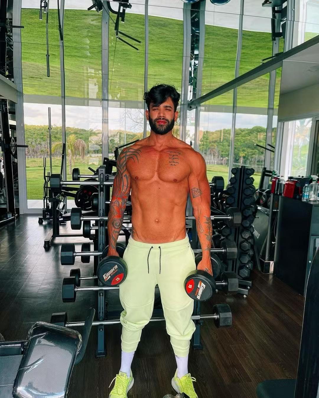 Foto: Reprodução/Instagram Gusttavo Lima sem camisa segurando halteres.