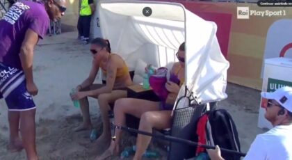 Imagem mostra o técnico em pé gritando com as jogadoras sentadas em cadeiras.
