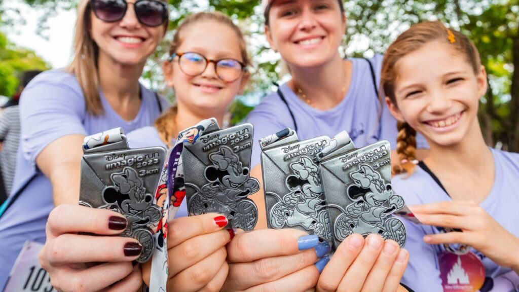 Imagem de pessoas mostrando as medalhas da corrida da Disney