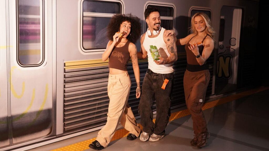 Imagem de três dançarinos da FitDance comendo snacks da Fitzei