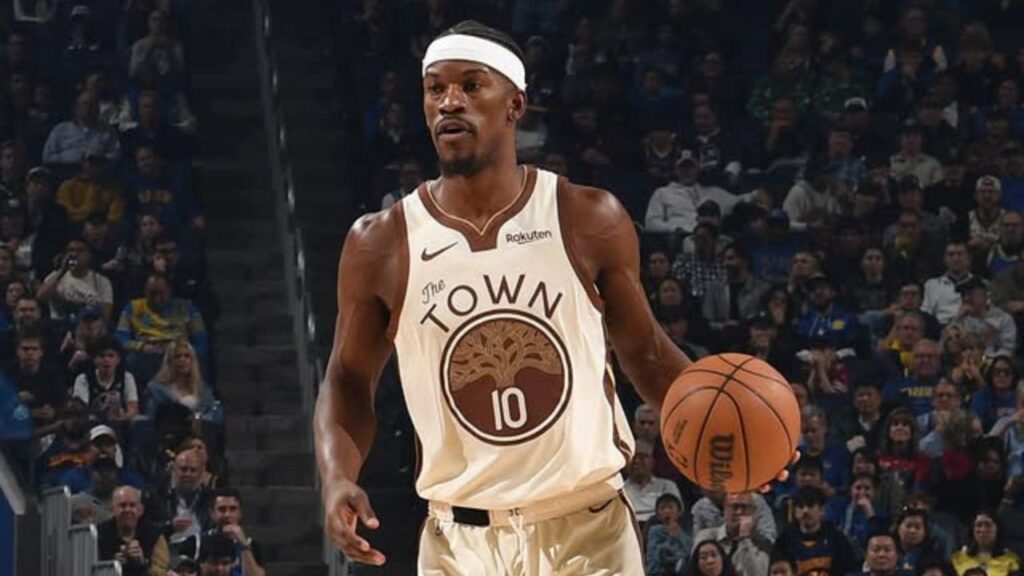 Imagem de Jimmy Butler com o uniforme do Golden State Warriors segurando uma bola de basquete