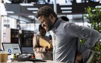 Homem negro sentado na cadeira do escritório com má postura.