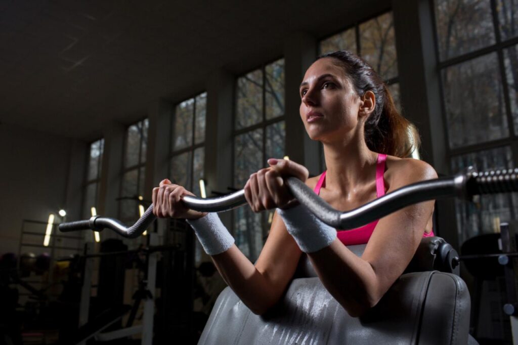 Mulher fazendo exercício de braço na academia.