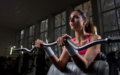 Mulher fazendo exercício de braço na academia.
